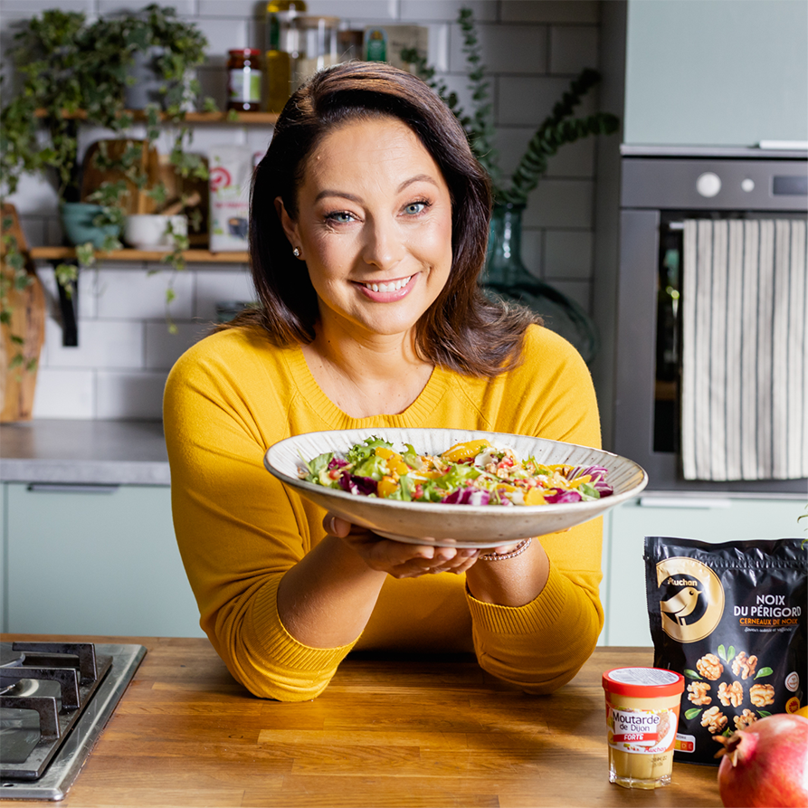 Pewni Dobrego brand ambassador, Jola Kleser, holding a plate with salad made of Pewni Dobrego products
